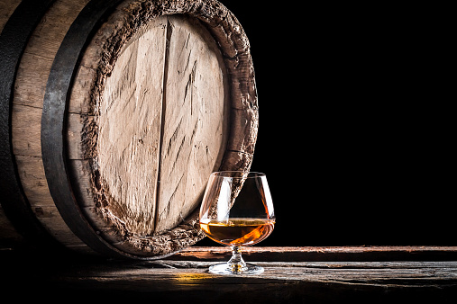 Old barrel and a glass of cognac.